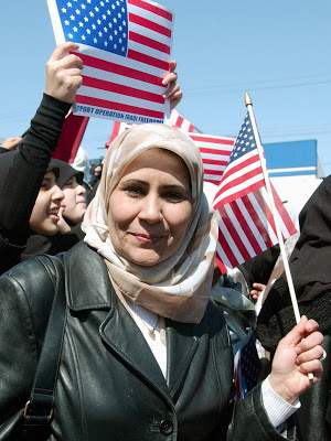 photograph of Muslim women waving American flags